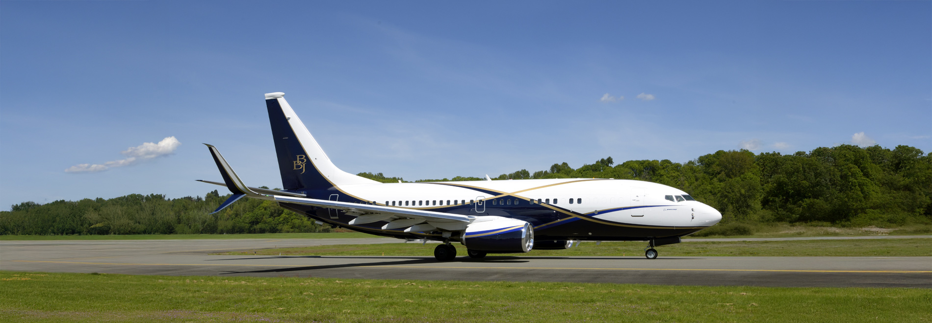 Boeing business jet flying against dark blue sky with clouds