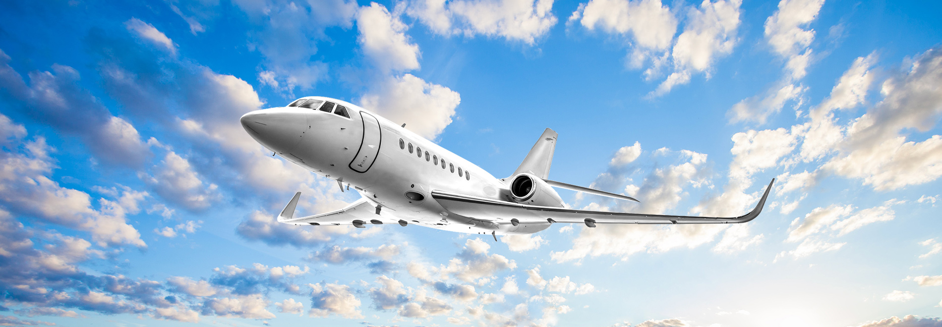 Falcon series aircraft flying against blue sky with clouds